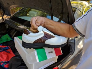 Übergabe auf dem Golfplatz-Parkplatz: weiß-brauner Herrenschuh